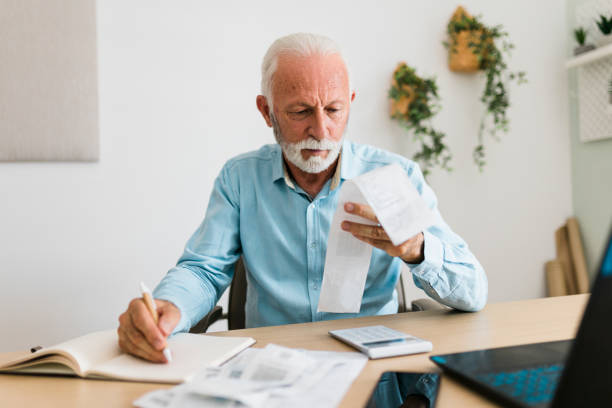 istock Senior man checking bills at home office 1437584250