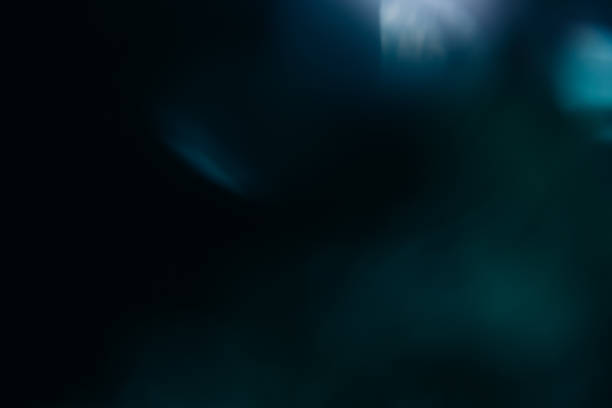 istock bokeh lens flare blur glow overlay blue light dark 1437584520