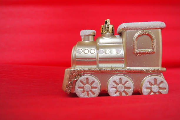 golden toy train locomotive on a red and pink gradient background. new year or christmas card. icicles and snow on a train. free space for text. copy space. festive background. - decor christmas celebration event christmas ornament imagens e fotografias de stock
