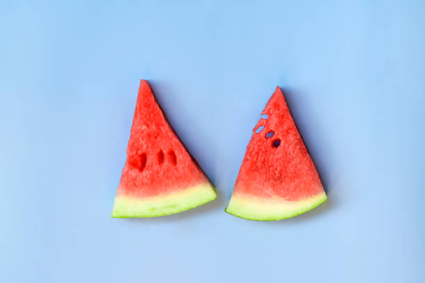 istock Two ripe pieces of watermelon. Blue summer background. 1437585892