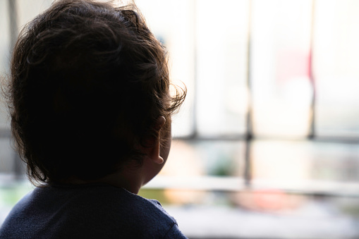 boy looking through the railing of a balcony