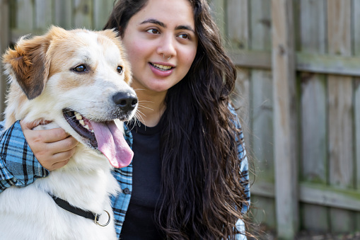 Nepalese young woman enjoys her day off work by taking her pet Great Pyrenees to the dog park.