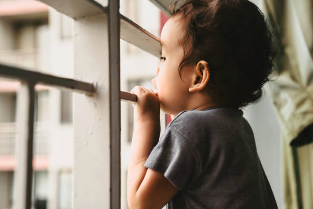 istock boy looking through the railing of a balcony 1437588961