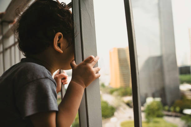 istock boy looking through the railing of a balcony 1437588962