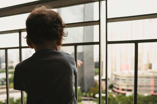 istock boy looking through the railing of a balcony 1437588971