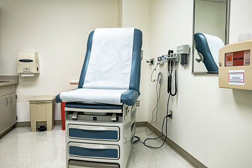 Empty medical oncology doctor office examination room with the examination table/reclining chair in its most upright position - ready for the next patient. While generic in appearance, equipment, etc., this exam room happens to be located in a large, regional, USA university cancer teaching and full service medical care center.