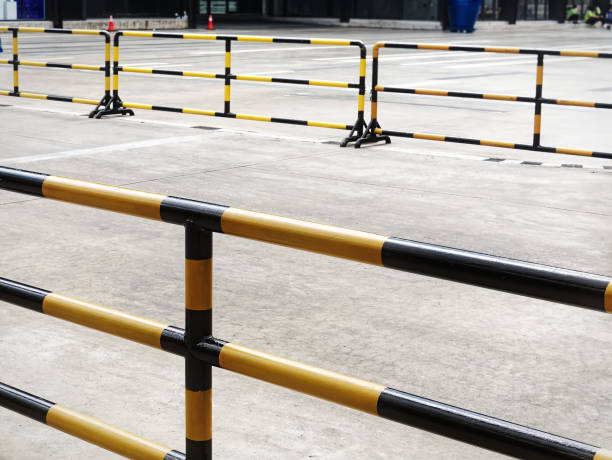 high angle view of yellow black striped metal fences along the road - walking point of view imagens e fotografias de stock