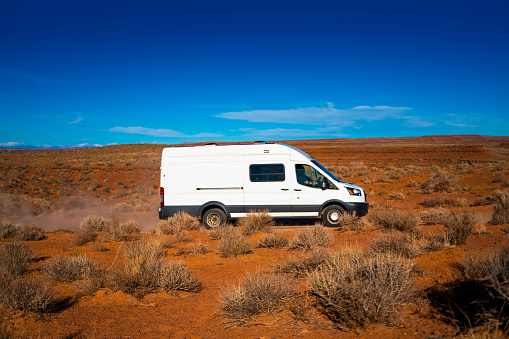 Delivery commercial van driving on a dirt road of the Arizona desert