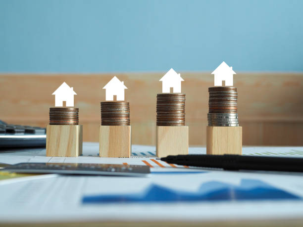 mini houses at the top of different sets of stacked coins