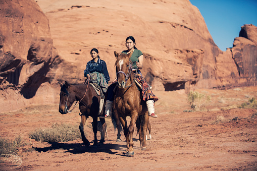 Navajo sisters riding on horses