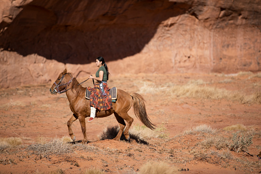 Navajo woman riding a horse