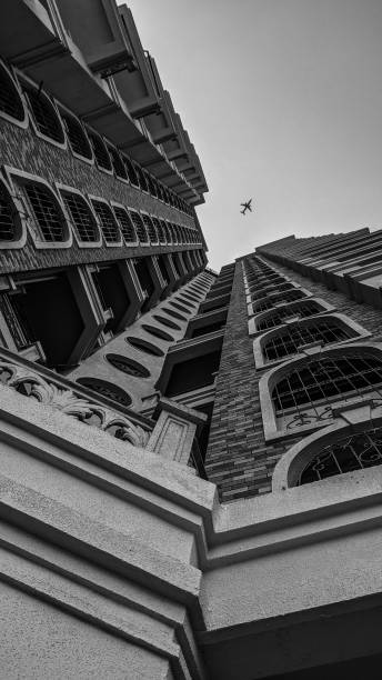 istock Black and white image of a building and airoplane in the sky. 1437608638