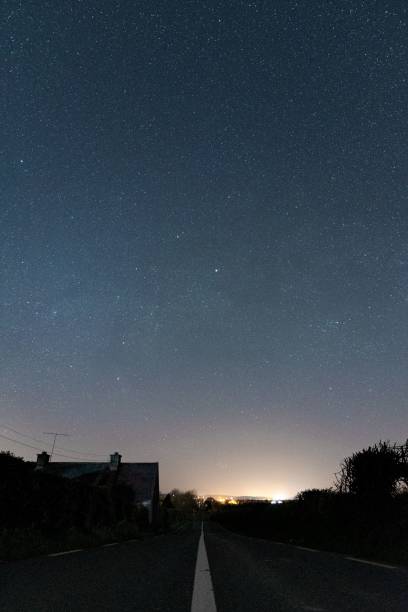 istock Vertical shot of an empty asphalt road under a blue starry sky at sunrise 1437627085