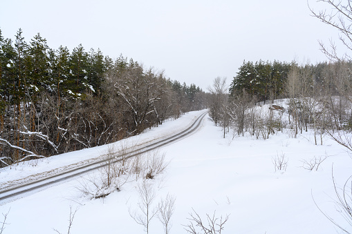 Snowy winter road in a mountain forest. Beautiful winter landscape.