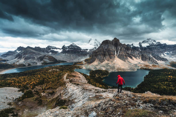 Moody of Nublet peak with mount Assiniboine and hiker standing in autumn at national park stock photo