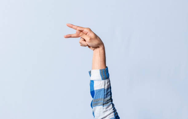istock Hand gesturing the letter P in sign language on an isolated background. Man's hand gesturing the letter P of the alphabet isolated. Letter P of the alphabet in sign language 1437628362