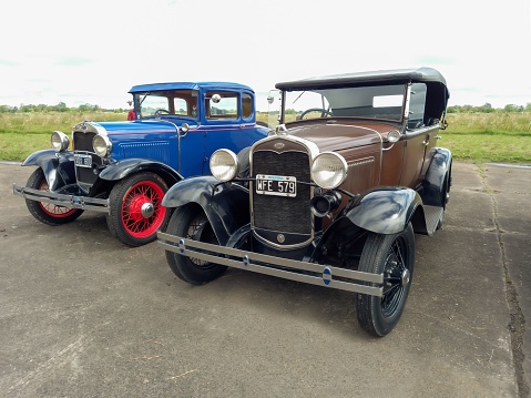 Avellaneda, Argentina – March 27, 2022: Old brown Ford Model A Phaeton Fordor four door and blue coupe Tudor two door circa 1930. Front view. CADEAA MNA 2022 classic car show.