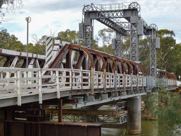 istock Old metal bridge above the river surrounded by green vegetation. 1437637558