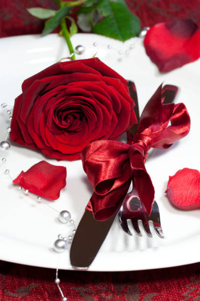 istock Vertical shot of a plate with a red rose on a festive table 1437639420