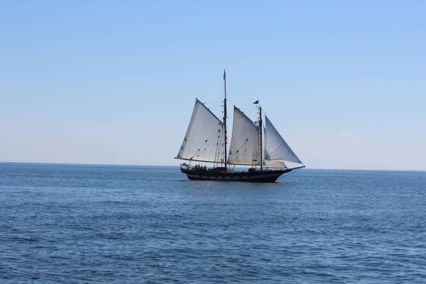 istock Old navy ship sailing on open seawater under a calm blue sky 1437641677