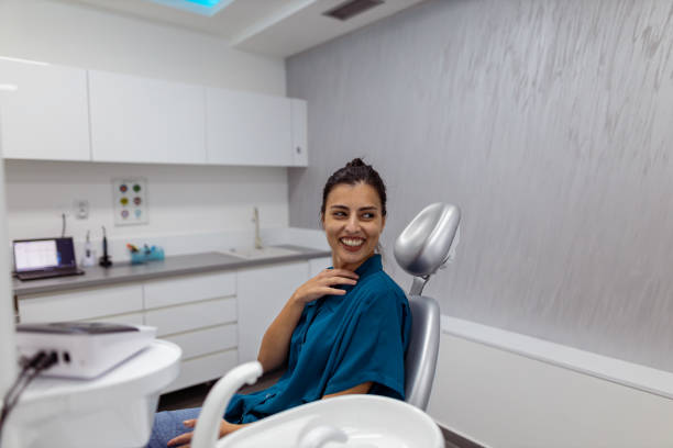 A beautiful and healthy smile A shot of a beautiful and happy young woman sitting in a dental chair smiling. dental drill stock pictures, royalty-free photos & images