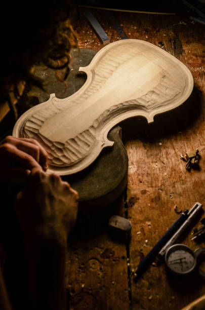 mujer artesana fabricante de violines luthier trabajando en un nuevo violín - fabricante de instrumentos fotografías e imágenes de stock