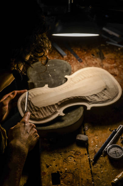 mujer artesana fabricante de violines luthier trabajando en un nuevo violín - fabricante de instrumentos fotografías e imágenes de stock