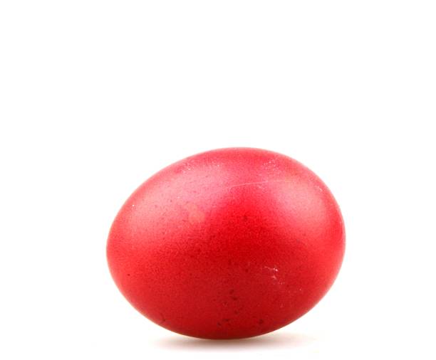 istock Closeup of a red painted egg for Easter under the lights isolated on a white background 1437643609