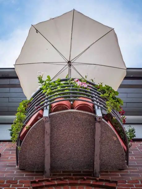 The photo shows a small balcony with a parasol in view from below.