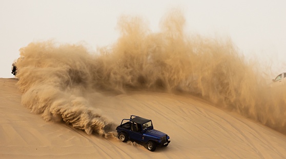 Dammam, Saudi Arabia – August 24, 2021: An aerial shot of an off-road Jeep showing up on a desert sand