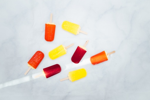 An aerial view of colorful popsicles in a blue background