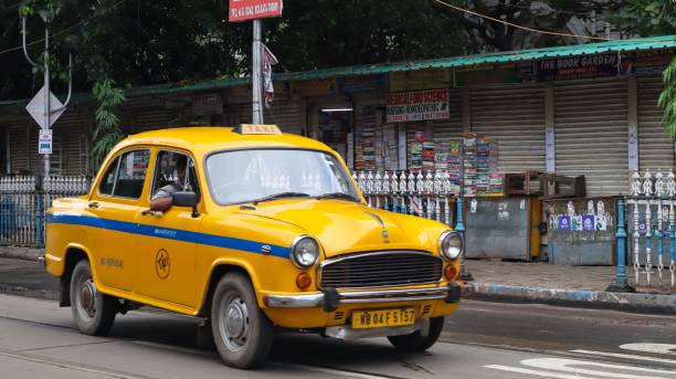 Yellow Taxi Standing on the Street of Kolkata. kolkata, India – October 16, 2021: Street of Kolkata During Festivals. Durga Pooja yellow taxi cab stock pictures, royalty-free photos & images