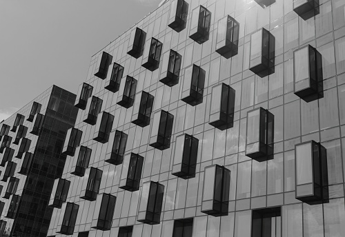 Grayscale of the facade of a modern office building with balconies