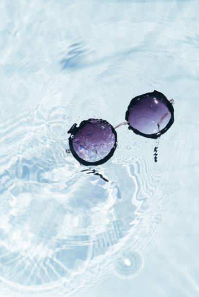 istock Top view of black sunglasses on pool water surface 1437645819