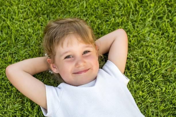istock Beautiful kid laying on the grass in the park 1437646051