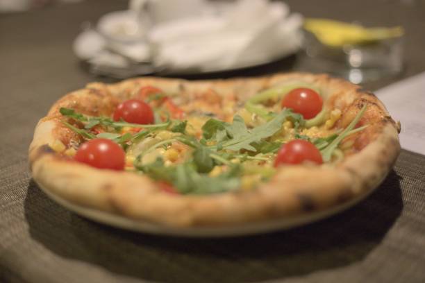istock Closeup shot of a pizza with cherry tomatoes on a dark brown table 1437646530