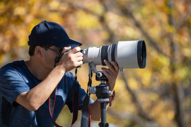 istock Young man using a DSLR camera in a forest in autumn 1437646922