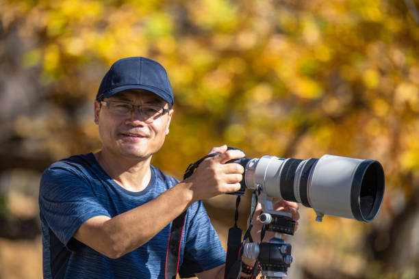 istock Young man using a DSLR camera in a forest in autumn 1437646950