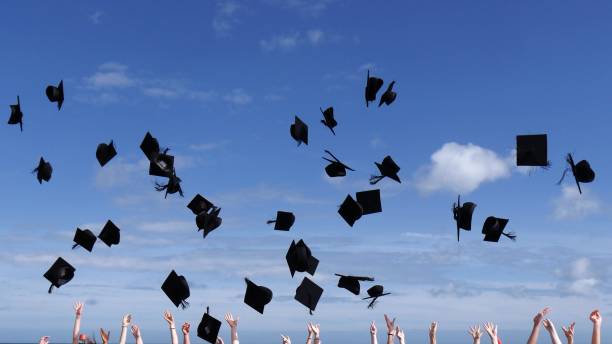 卒業祝賀会で空中に浮かぶ卒業帽 - high school sports ストックフォトと画像
