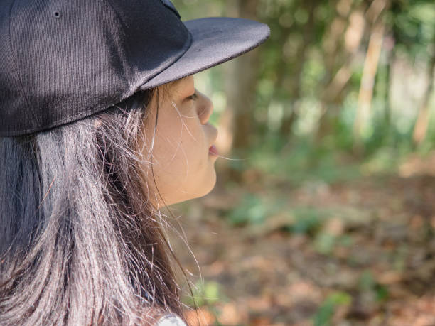 istock Happy young Asian woman with backpack walking on path in summer forest. 1437649408