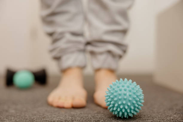 istock Woman doing flatfoot correction gymnastic exercise using massage ball. Myofascial relaxation of foot muscles. Hallux valgus. Pain. Identification of flat feet. Self care practices at home, healthcare. 1437649844