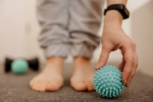 istock Woman doing flatfoot correction gymnastic exercise using massage ball. Myofascial relaxation of foot muscles. Hallux valgus. Pain. Identification of flat feet. Self care practices at home, healthcare. 1437649849