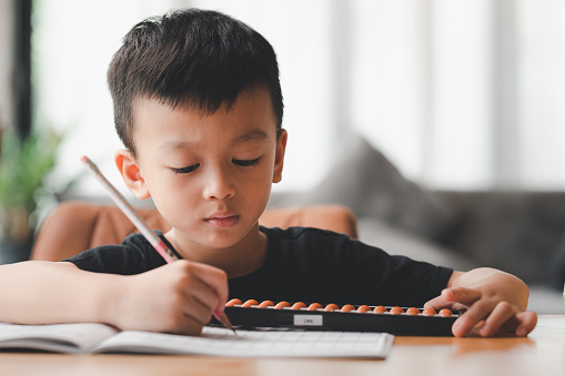 Asian boy Learning math with an abacus, education concept, home school, Social distancing, stay home, online learning class study math.