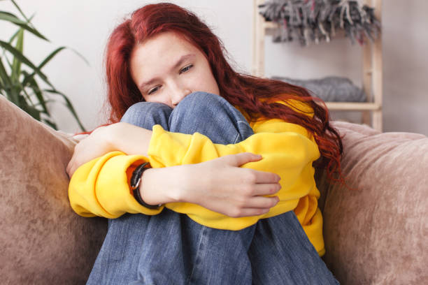 istock Upset thoughtful young woman sitting on couch 1437651823