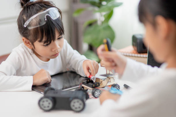 istock Two Asian students learn coding robot cars and electronic board cables in STEM, STEAM, mathematics engineering science technology computer code in robotics for kids concepts. 1437653882