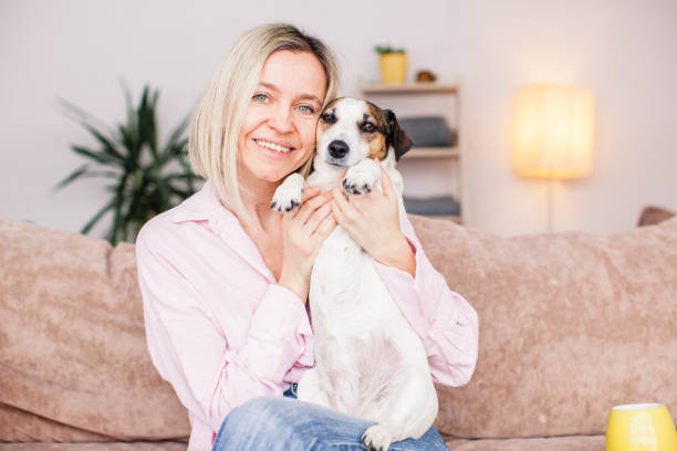 istock woman on couch with dog at home 1437656368