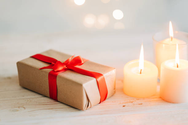 Saint Valentine day: red ribon, romantic gift box, candle on white background.