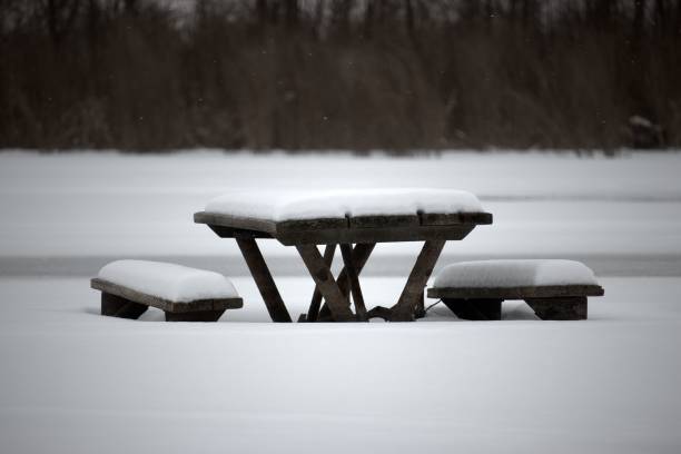 istock Wooden table and chairs under thick layer of snow in the park 1437658077