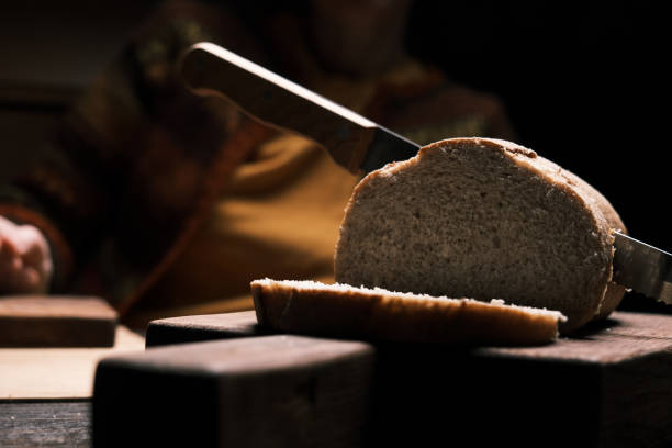Hands of a woman are preparing a toast with homemade apple marmalade and pouring a glass of hot tea