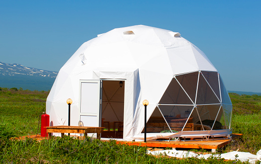 The white geodome tent. Cozy glamping, holiday, vacation lifestyle concept.